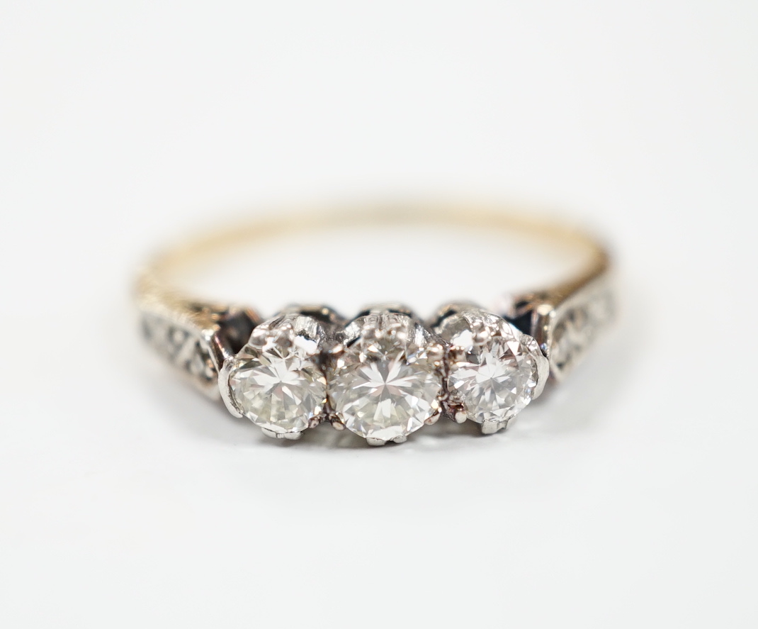 A yellow metal and three stone diamond set ring, with six stone diamond chip set shoulders, size L, gross weight 2.2 grams.